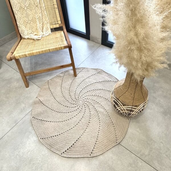 Tapis rond au crochet de 100 cm avec un motif spirale ajouré, réalisé avec le kit crochet DIY comprenant du fil naturel et un tutoriel vidéo détaillé par LesPetitesBouill.