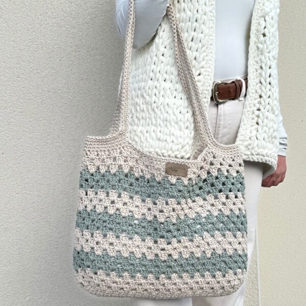 Sac en crochet granny beige et vert sauge porté sur l’épaule, réalisé avec le kit crochet Lou Pass