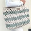 Sac en crochet granny beige et vert sauge porté sur l’épaule, réalisé avec le kit crochet Lou Pass
