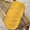 Pelote de Trapilho Satin Stretch Moutarde sur fond bohème avec fleurs séchées