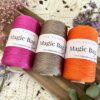 Pelotes de fil Magic Bag Slim 100% polypropylène en trois couleurs : rose fuchsia, taupe satiné et orange vif - idéales pour la création de sacs et d’accessoires au crochet.