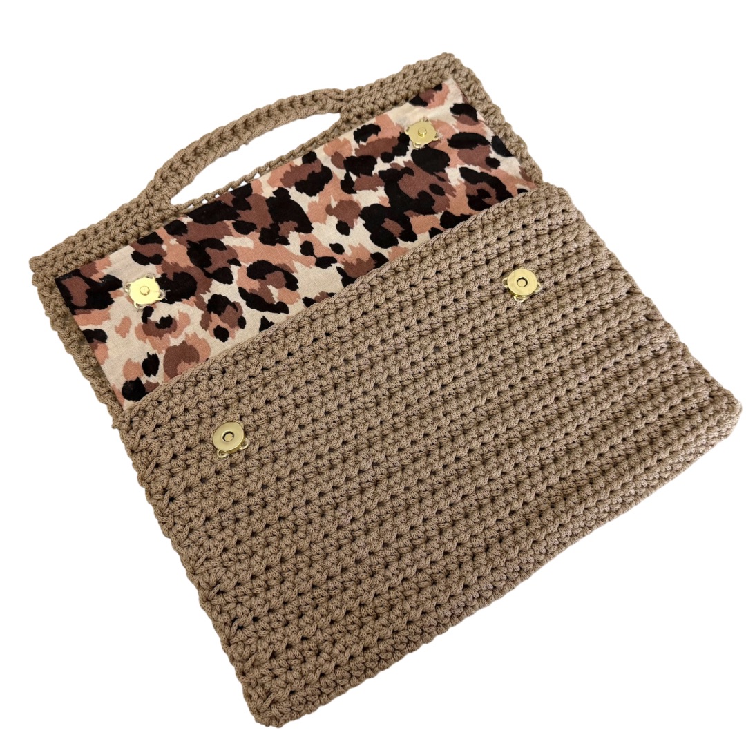 Pochette au crochet beige réalisée avec le fil Magic Bag Lou Passion, fermée avec label doré “Fait Main” sur le rabat.