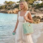 Femme portant un sac crochet Sunshine vert en fil Boho au bord de la mer