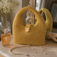 Sac au crochet au design moderne avec anses intégrées, réalisé en fil Fio Náutico. Ce modèle est proposé en tutoriel pas à pas sur la chaîne YouTube Lou Passion. Idéal pour un sac du quotidien, résistant et tendance.