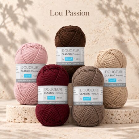 Pelotes Douceur Classic Premium Trimits en rose tendre, bordeaux, marron, taupe et beige sur un fond travertin.