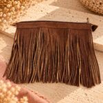 Fermeture à glissière en simili cuir cognac de 25 cm avec franges de 20 cm pour sac au crochet, sur fond travertin.